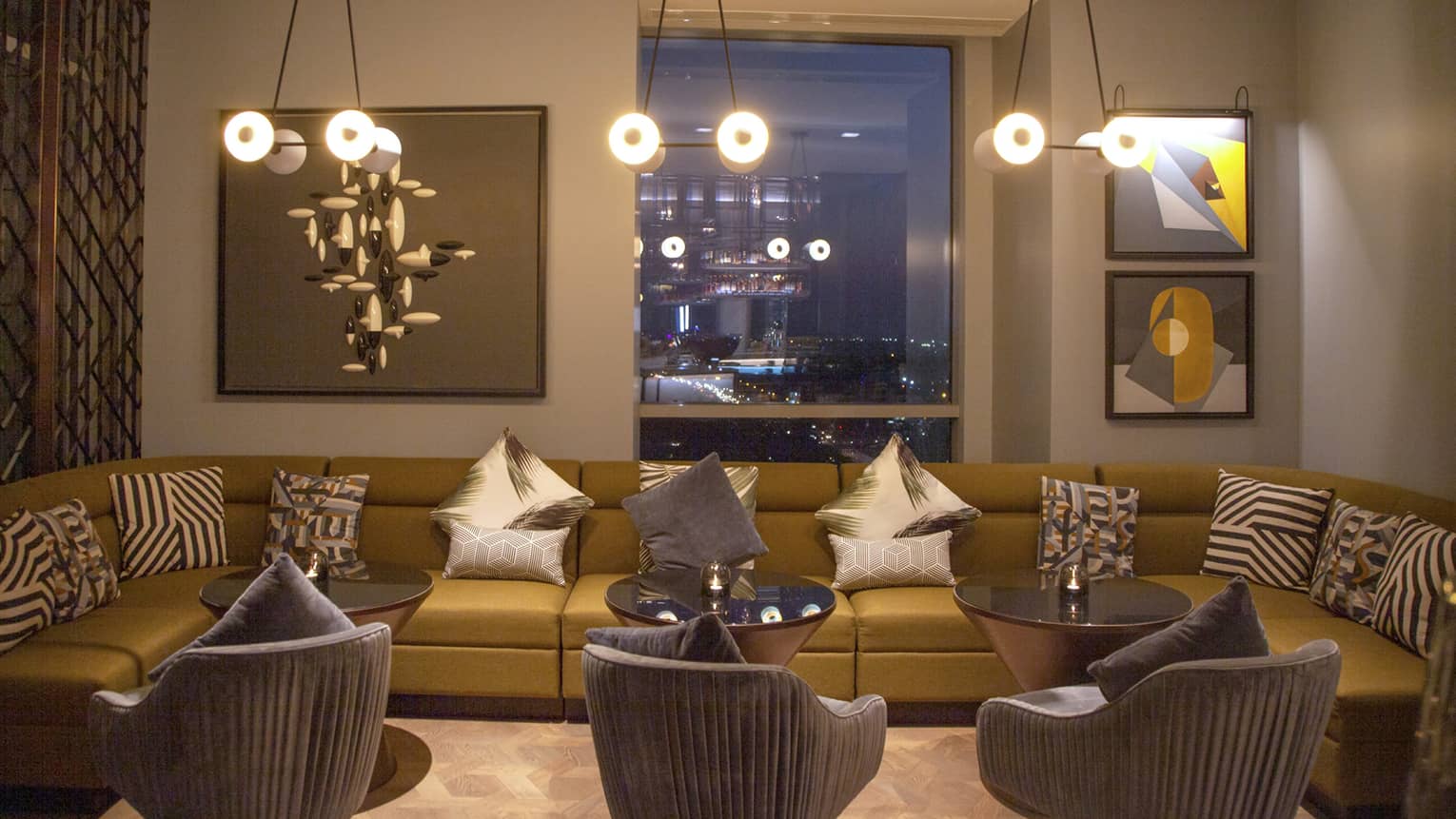 Copitas bar with long modern modular sofa, velvet armchairs under lights