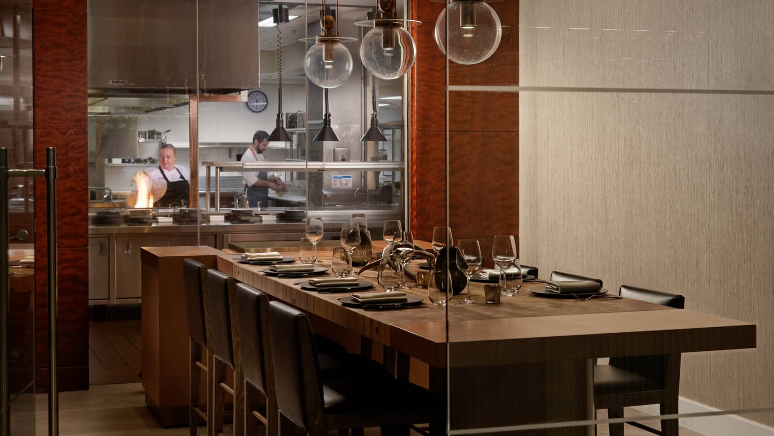 A large dining table next to an open kitchen.