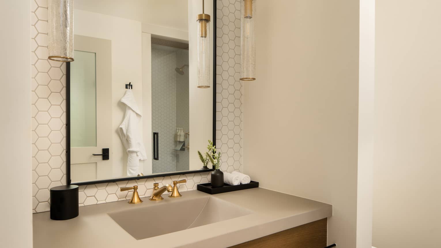 Modern vanity of bathroom, with tiled wall and hanging lights