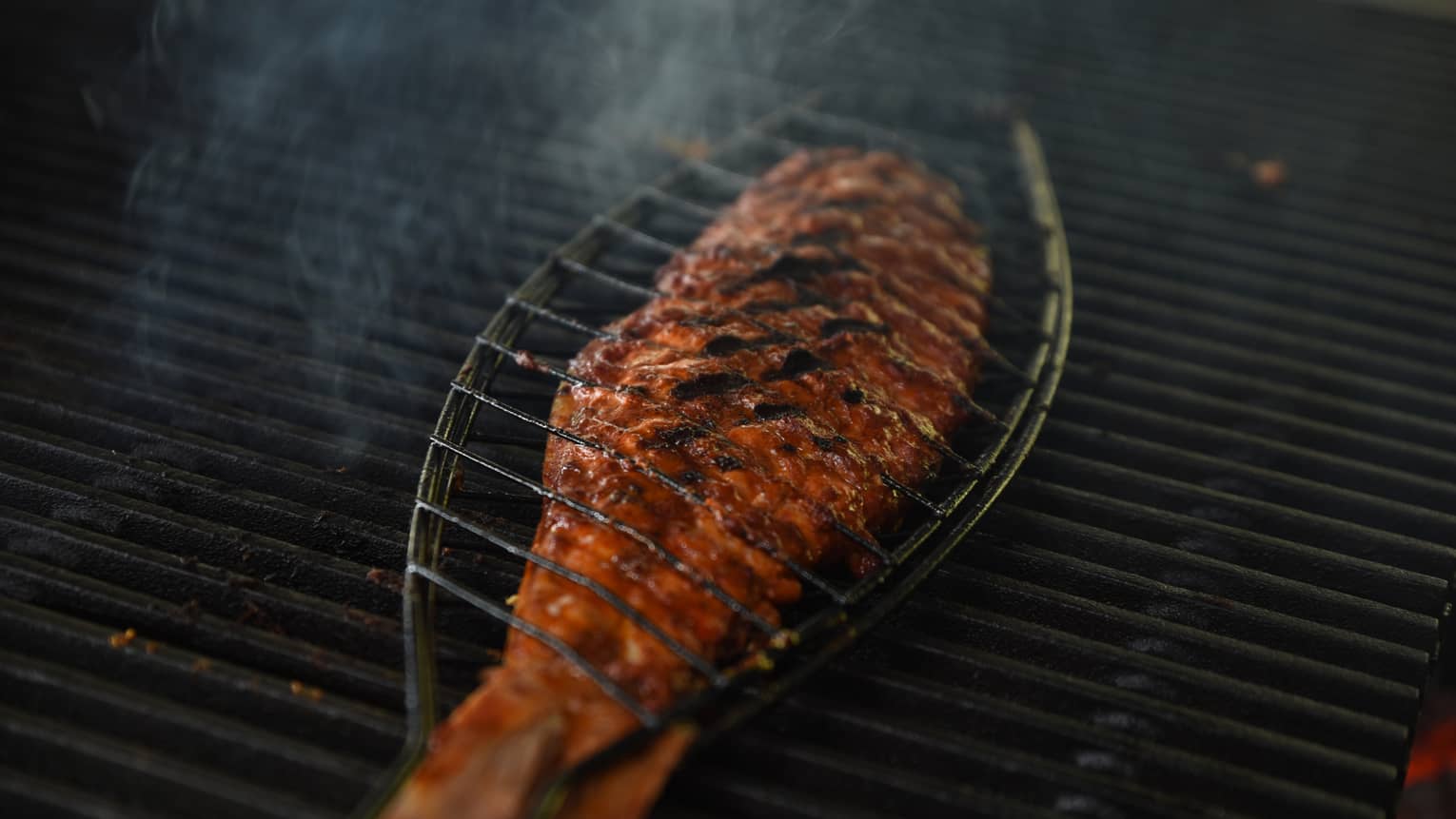 A fish cooking on a grill.