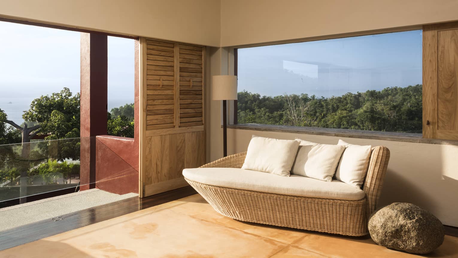 Room with a daybed, a window and walk-out terrace overlooking a lush reserve