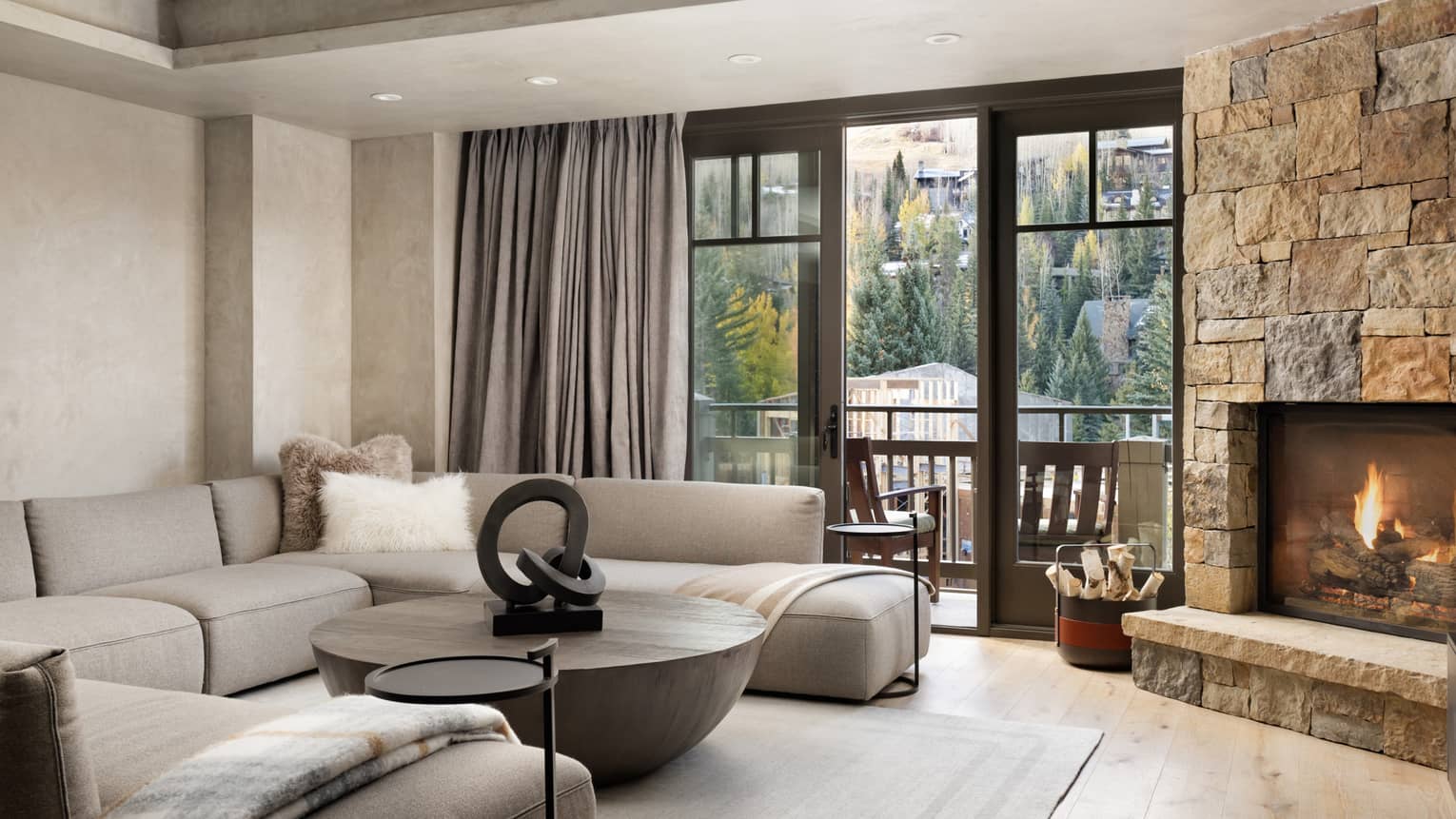 Living room with sectional sofa, stone hearth and fireplace, large round coffee table