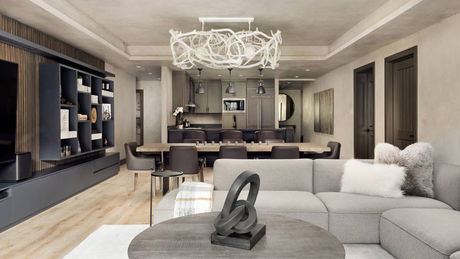 Sectional grey sofa, round coffee table, abstract chandelier and dining table