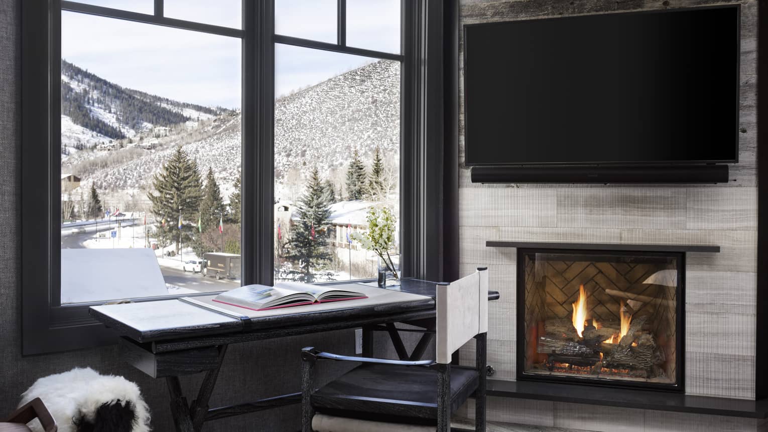 Desk at the window looking out to mountain, fireplace and wall-mounted TV