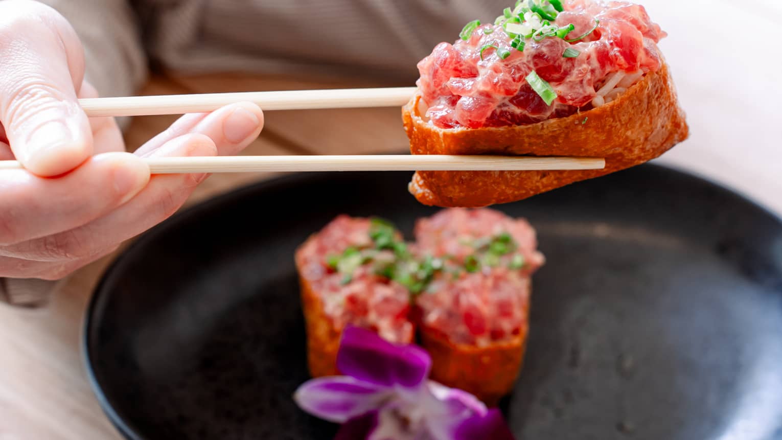 Person eats a poke dish with chop sticks