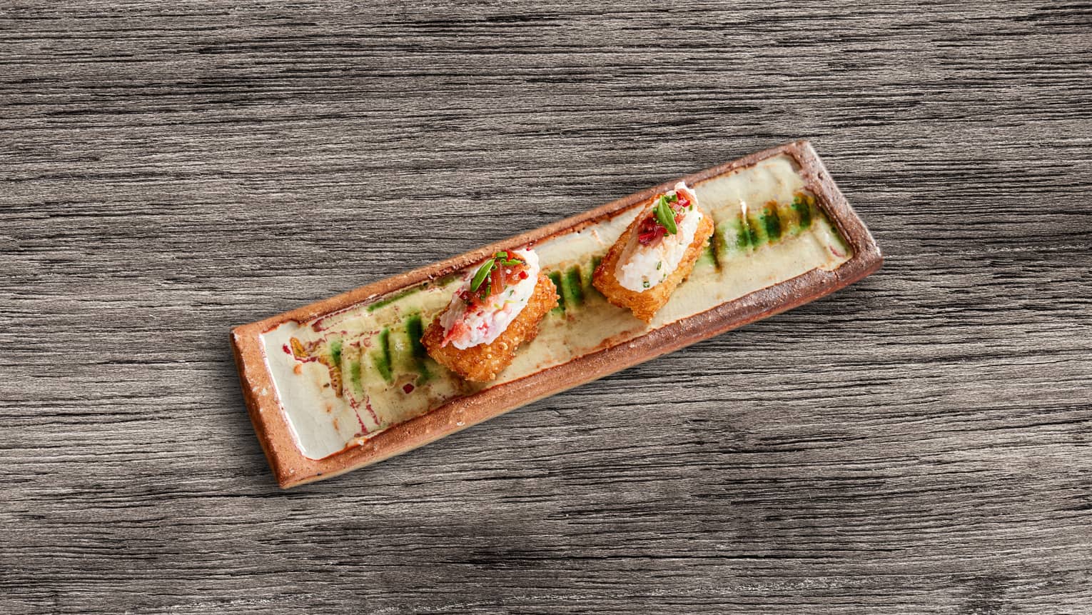 Crab and crispy rice on a small tray.