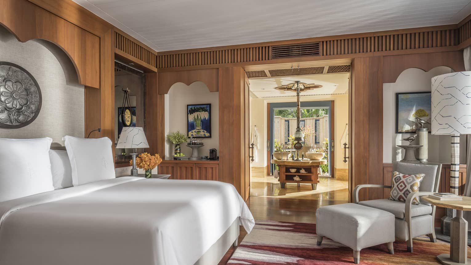 Lower Pavilion Room with white bed and gray club chair
