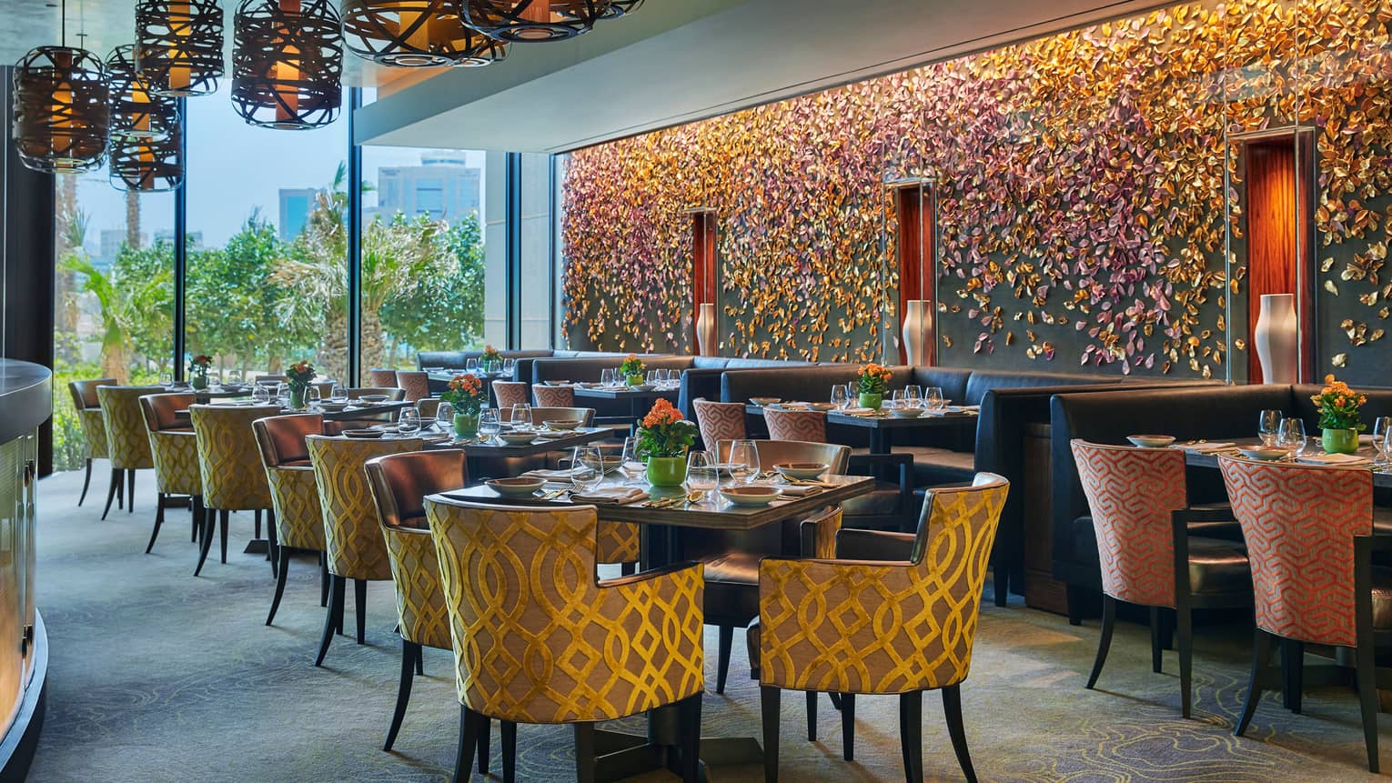 Bahrain Bay Kitchen elegant indoor dining room with chairs with gold details, formal dining tables, flower-petal mural