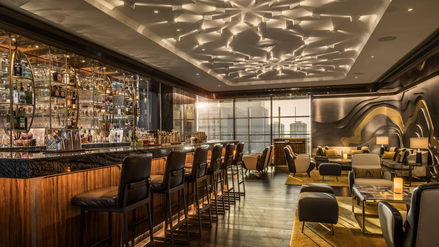 Luna Sky Bar dimly-lit lounge with long illuminated bar and liquor display, cocktail tables with leather stools