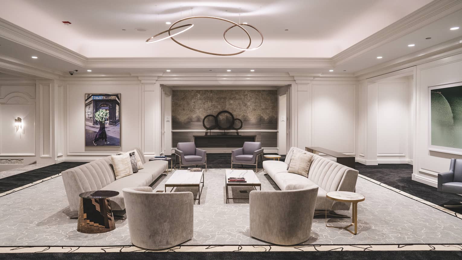 A lounge area with sofas, coffee tables and chairs.