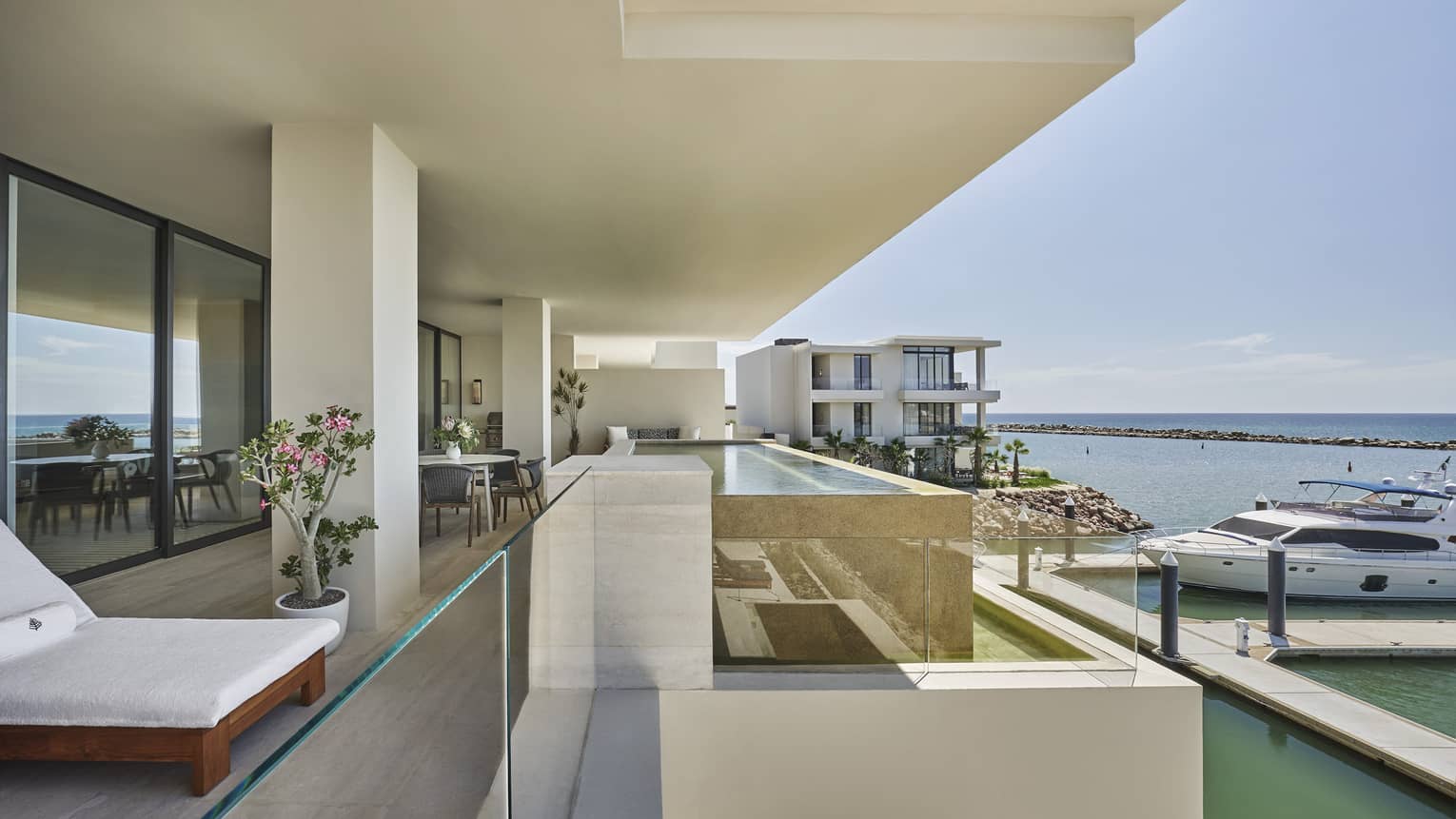 Modern balcony with glass railing, overlooking boat harbour