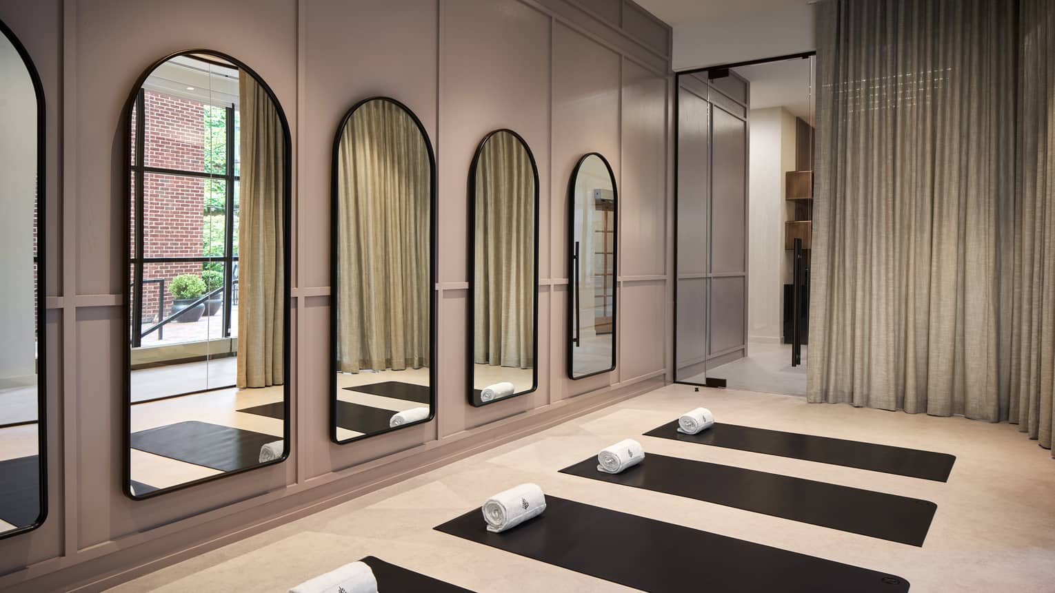 Yoga mats in a yoga studio with mirrors on the wall.