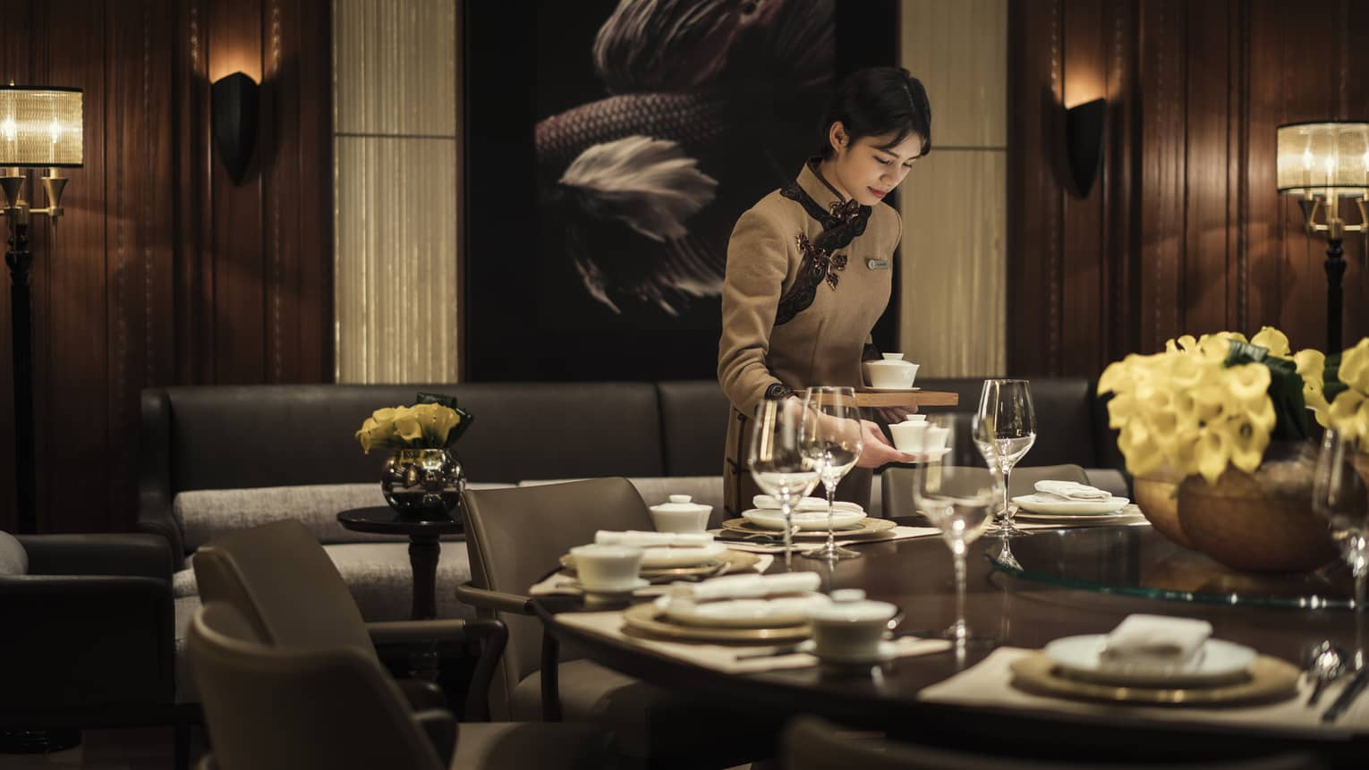 Hotel staff sets dishes on restaurant table