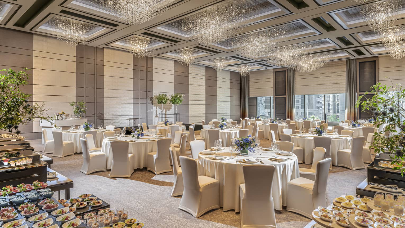 Grand Ballroom set up for a wedding with food, white linens and floral arrangements