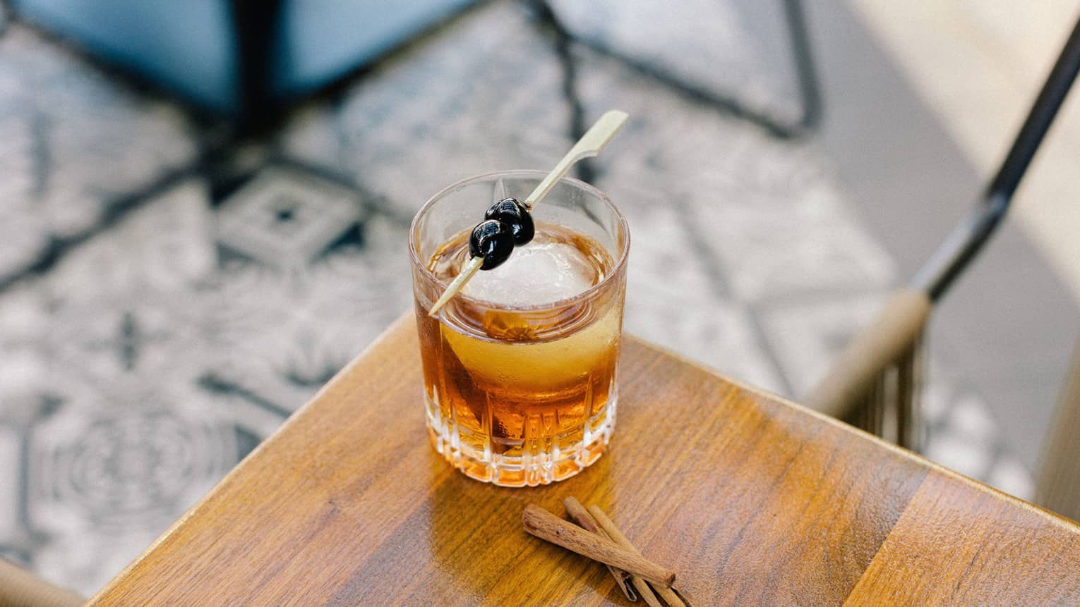 A cocktail with blueberries as a garnish.