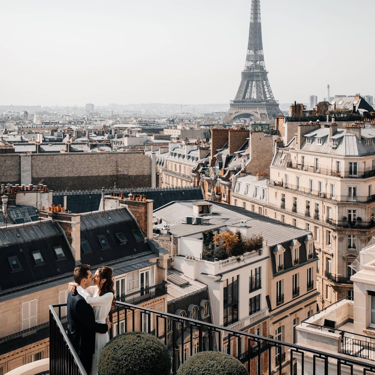Couple embracing on Paris Hotel terrace with Eiffel Tower view