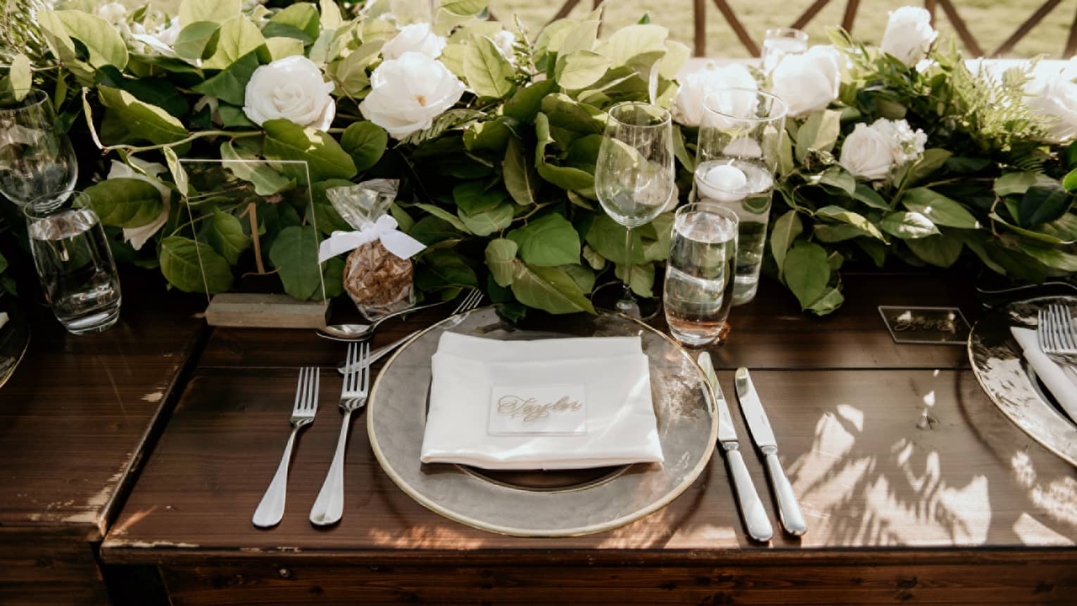 Elegantly set dining table with crystal stemware and gardenia floral centrepiece