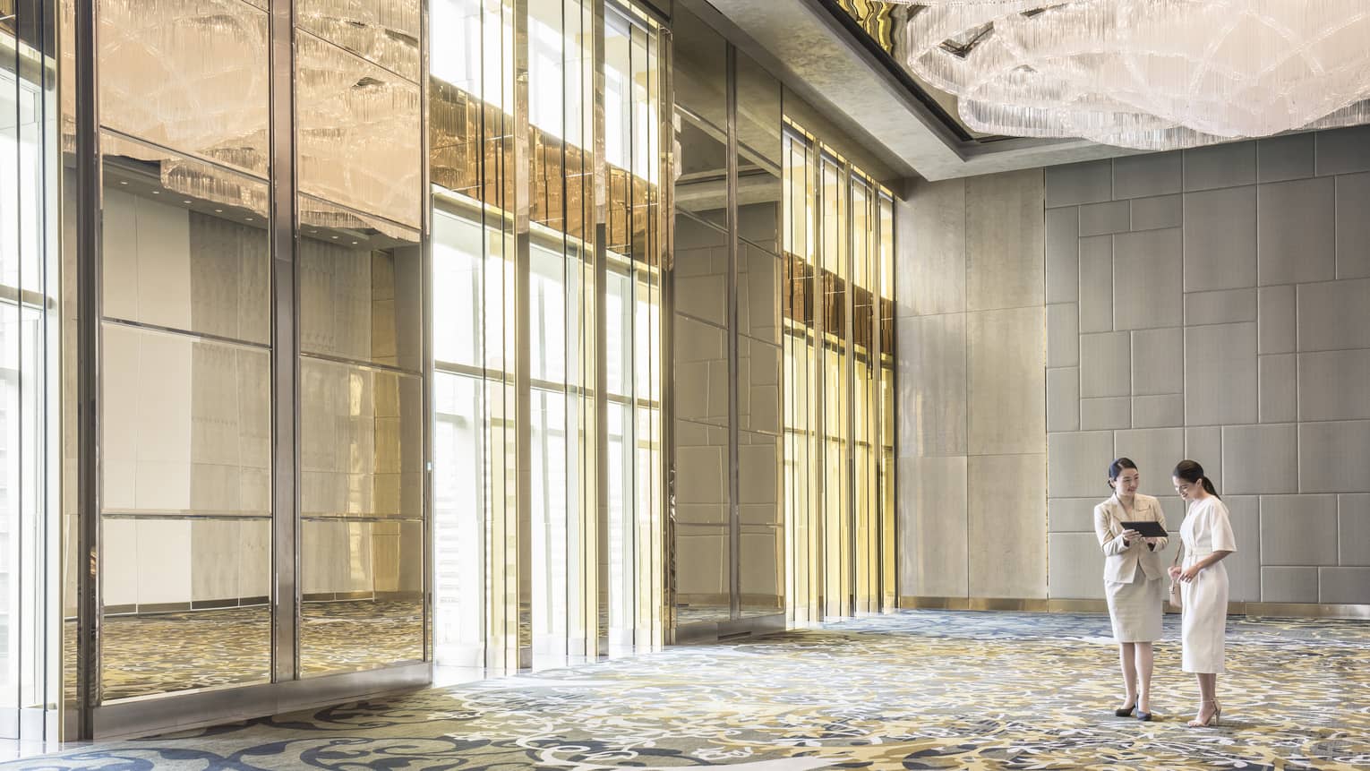 Wedding planner and bride in large empty banquet hall event space