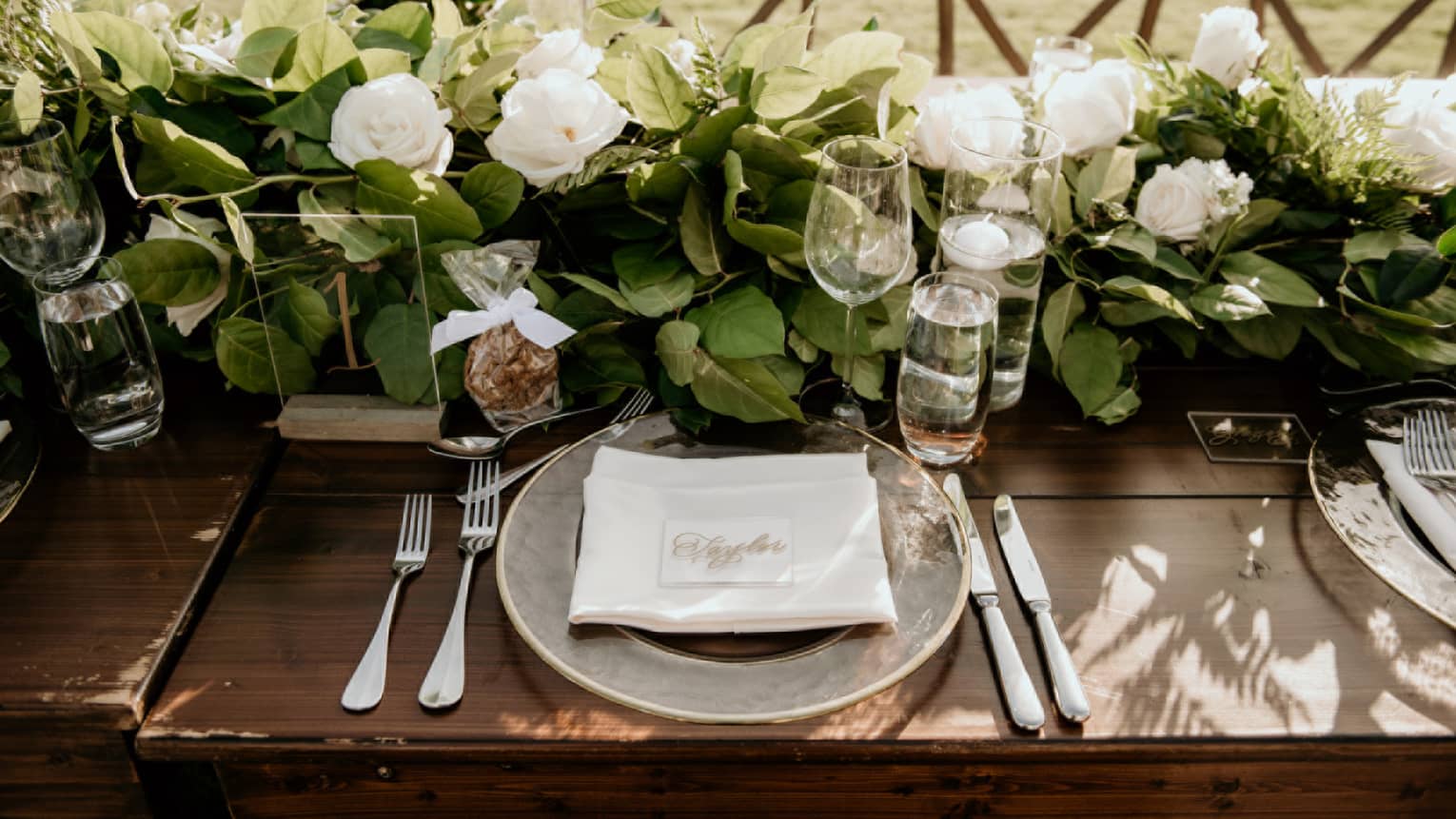 Elegantly set dining table with crystal stemware and gardenia floral centrepiece