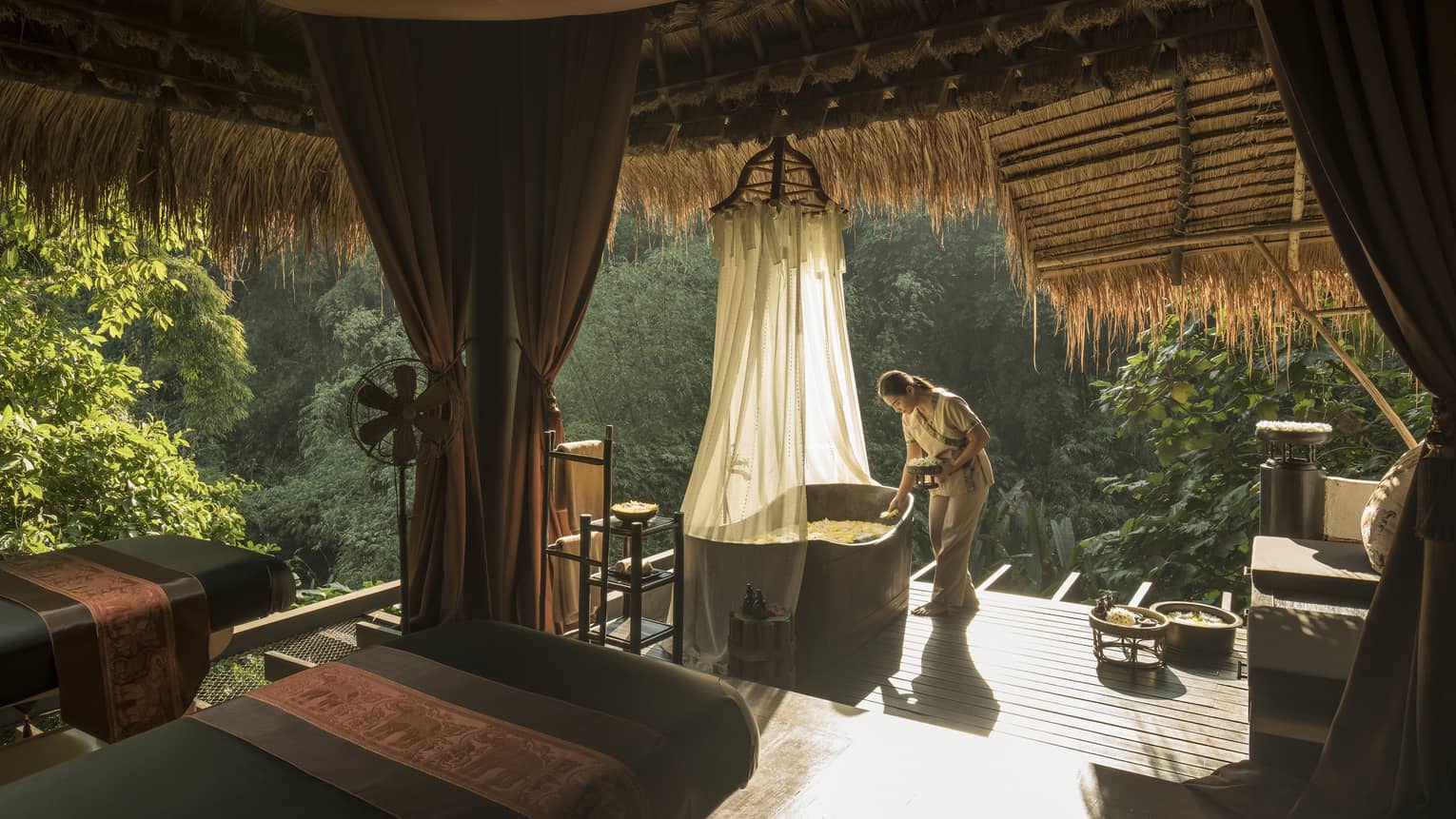 Woman prepares a bath on the jungle terrace