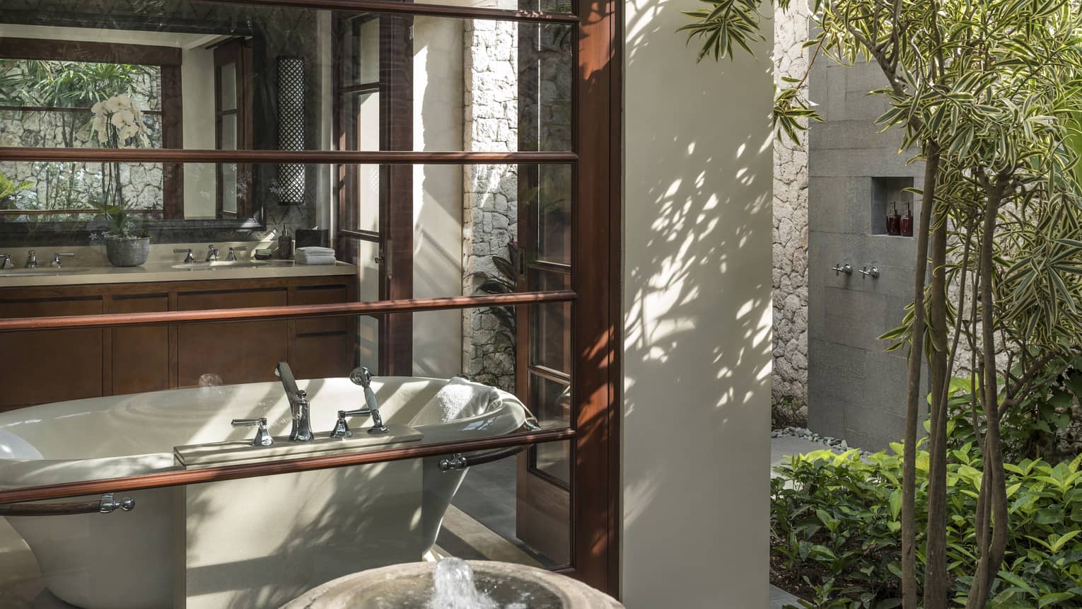 View from outside window looking at freestanding tub inside bathroom, sink