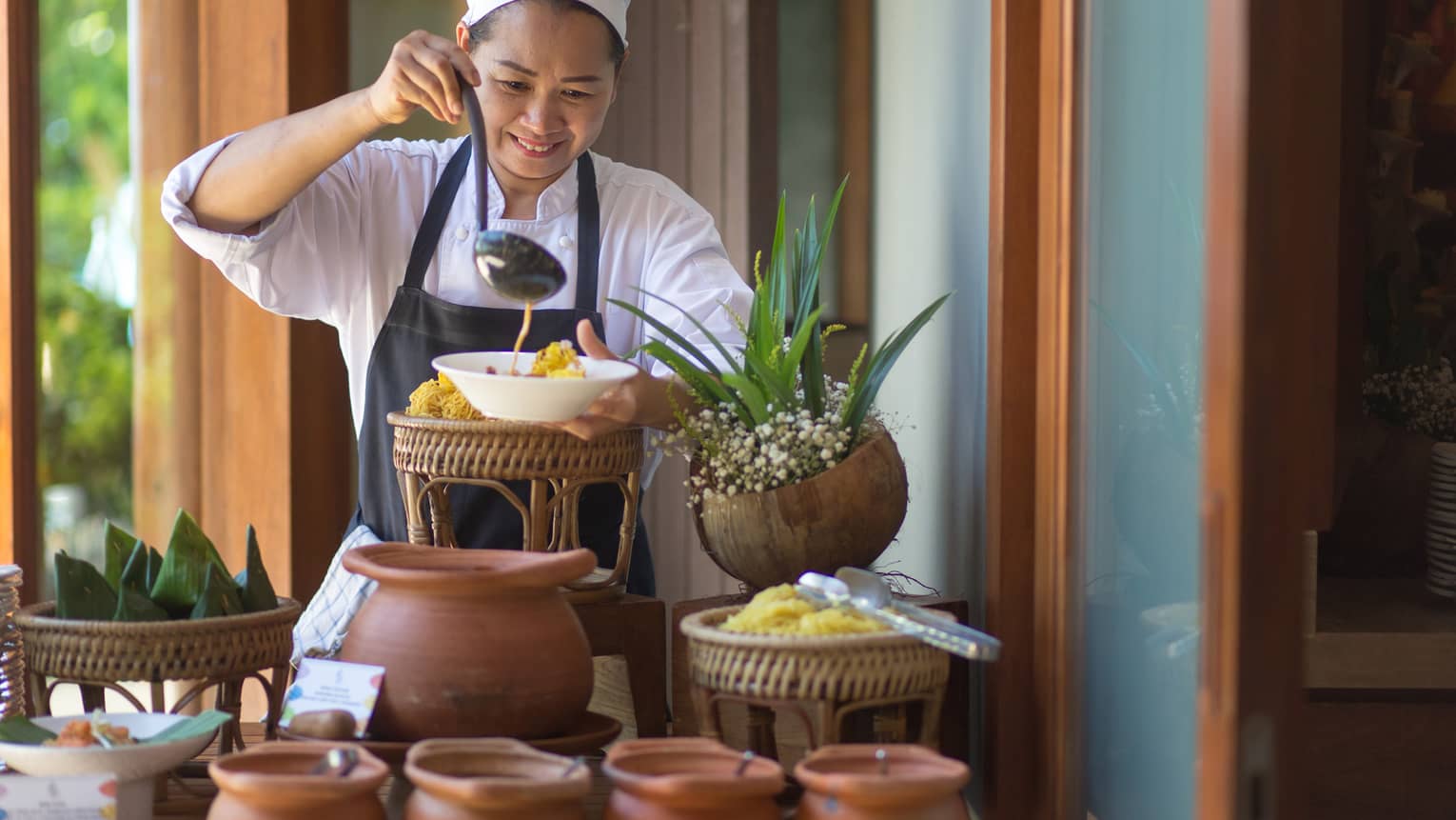 Sunday Brunch at the Khao Soy Station, chef ladles noodle soup into a bowl