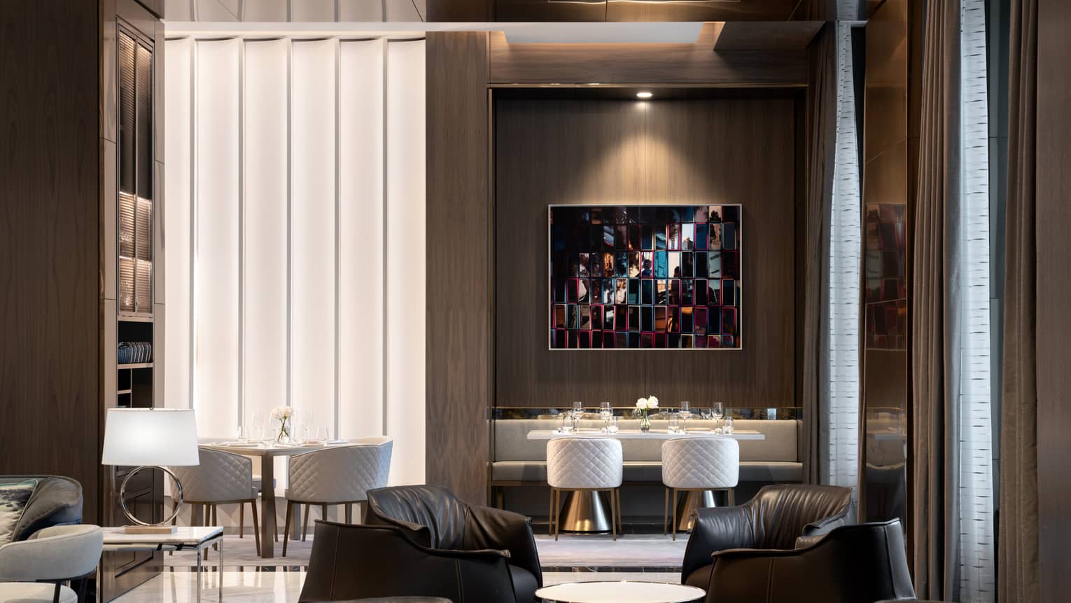A dimly lit lounge area with leather chairs and tables.