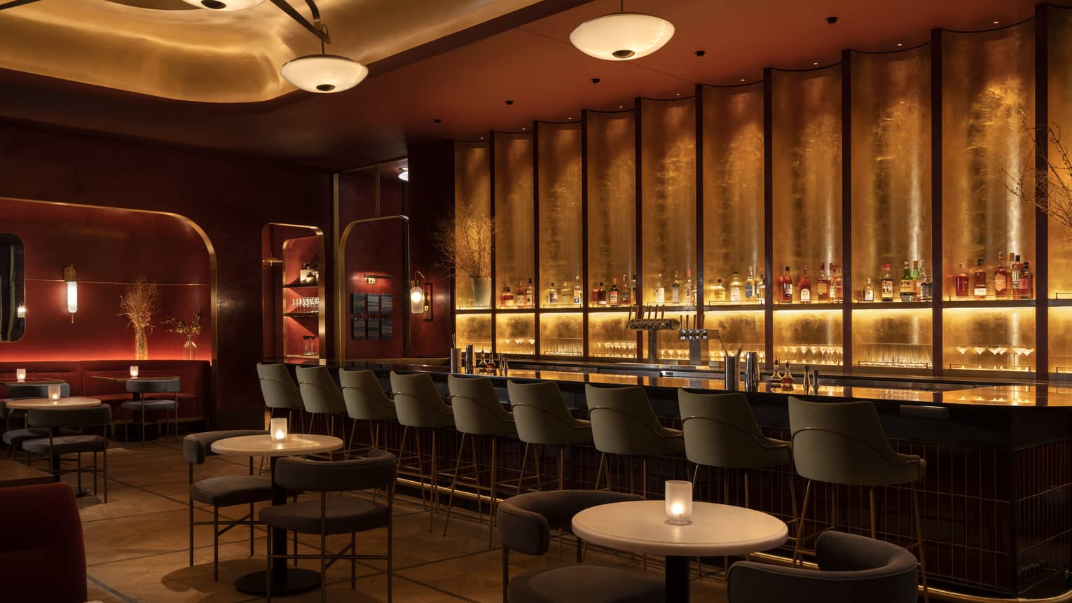 Interior of a dining room and bar with mid century modern seating, illuminated by warm lighting