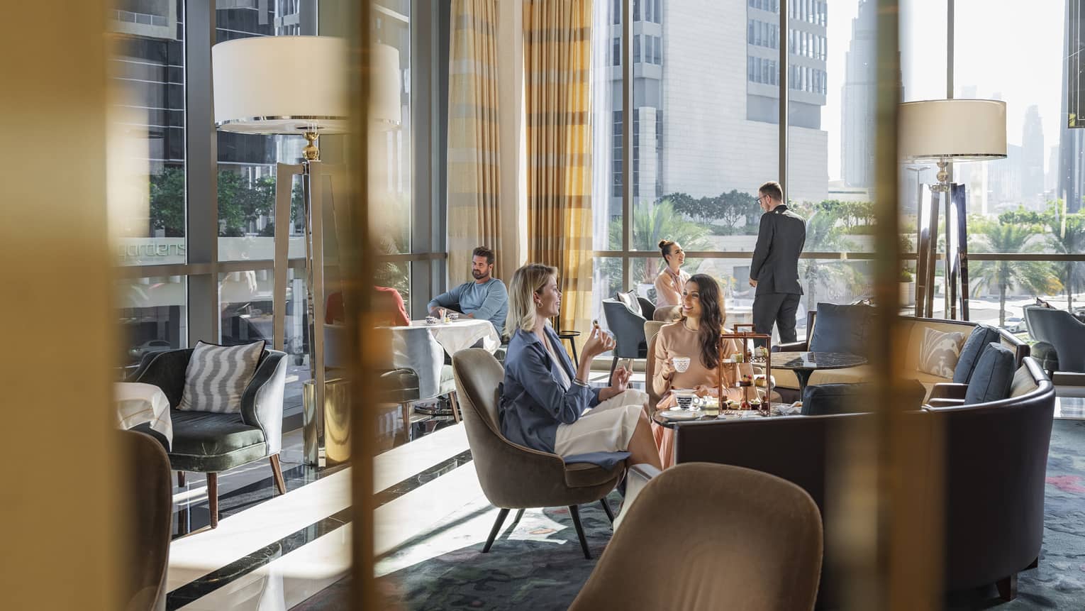 two ladies eating and drinking at city luxury hotel dining area