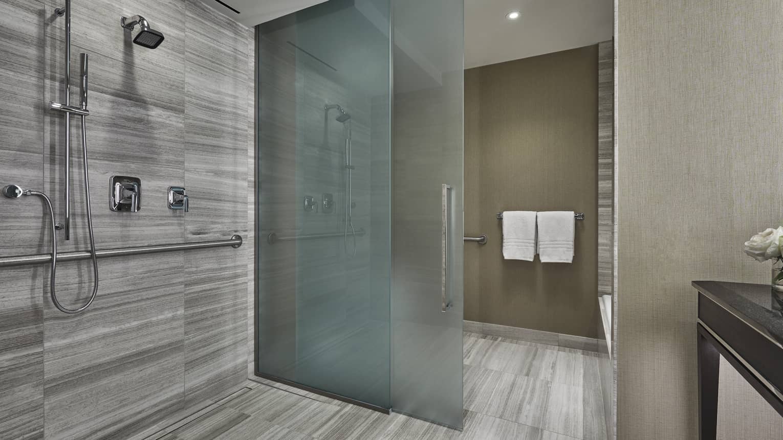 A large wet bathroom opens up into a four seasons hotel boston one dalton room. 
