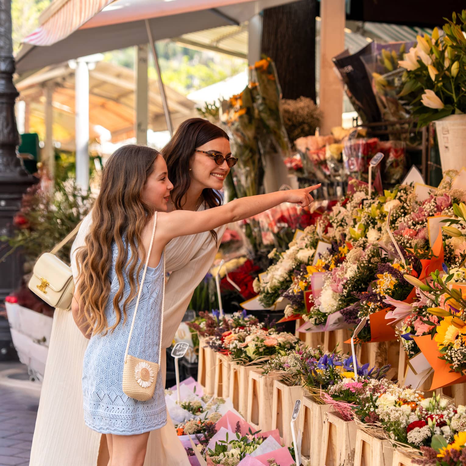 Two guests standing near a display of flowers at an outdoor shop