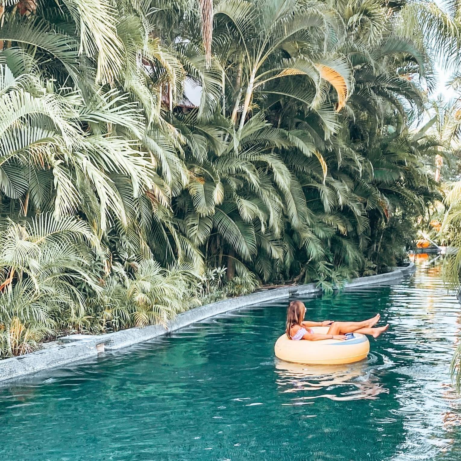 Captivating poolside moment at Four Seasons Resort Punta Mita, with a guest relaxing by the sparkling blue water under clear skies