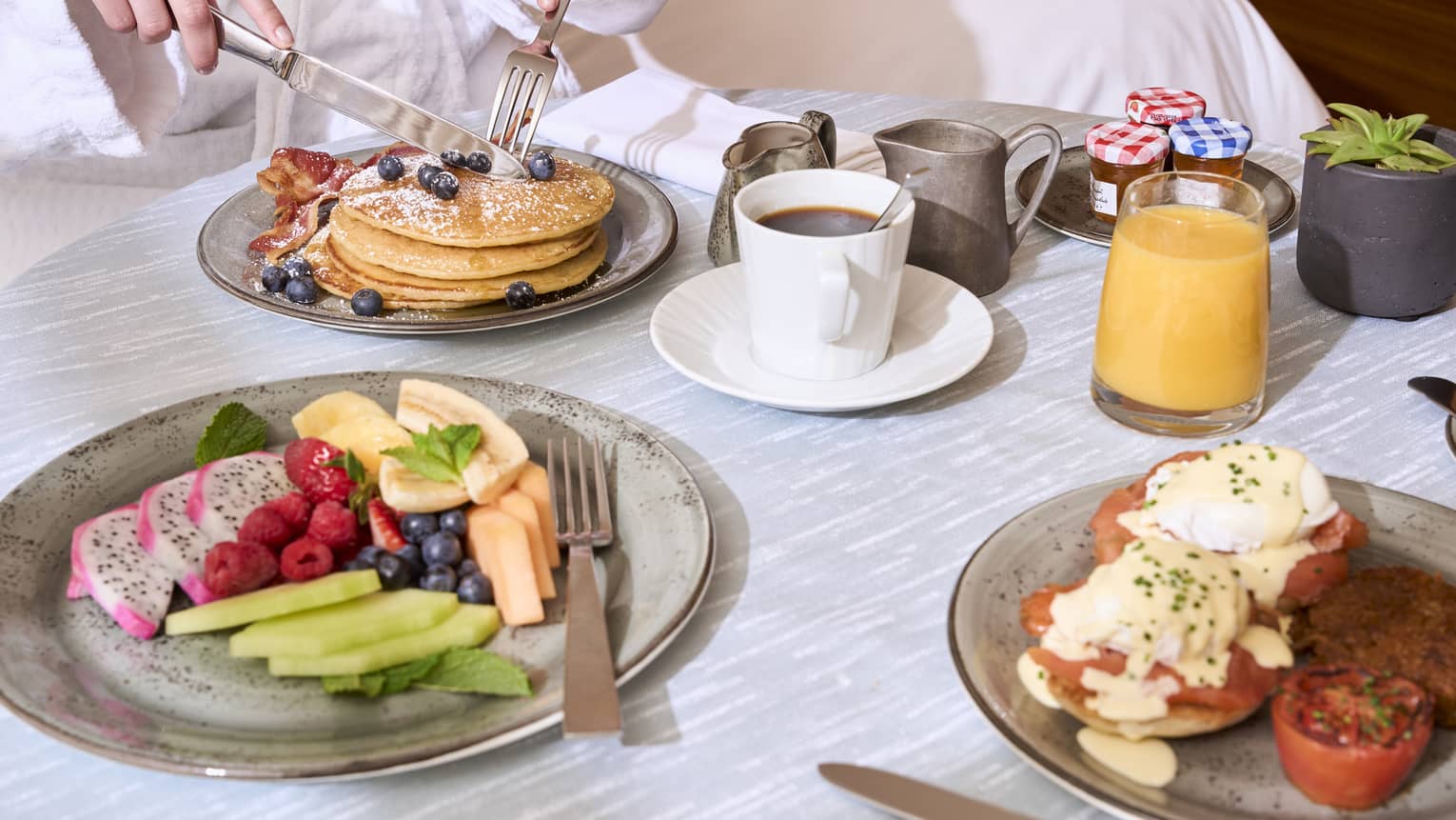 An assortment of breakfast food on a light grey table.