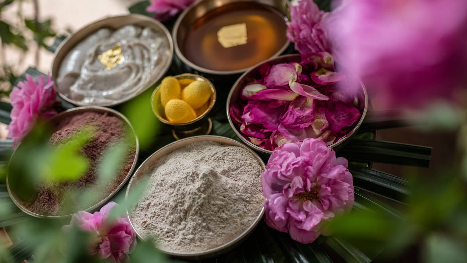 Close-up of bowls of powders, creams, lotions and flower petals, purple flowers