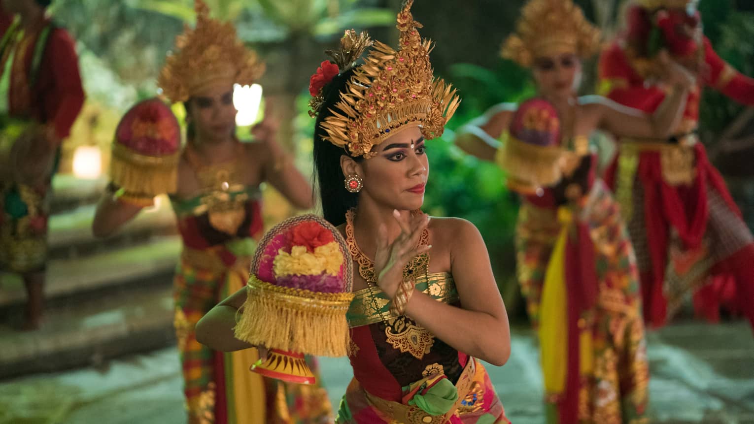 Traditional Balinese dancers performing outdoors at night