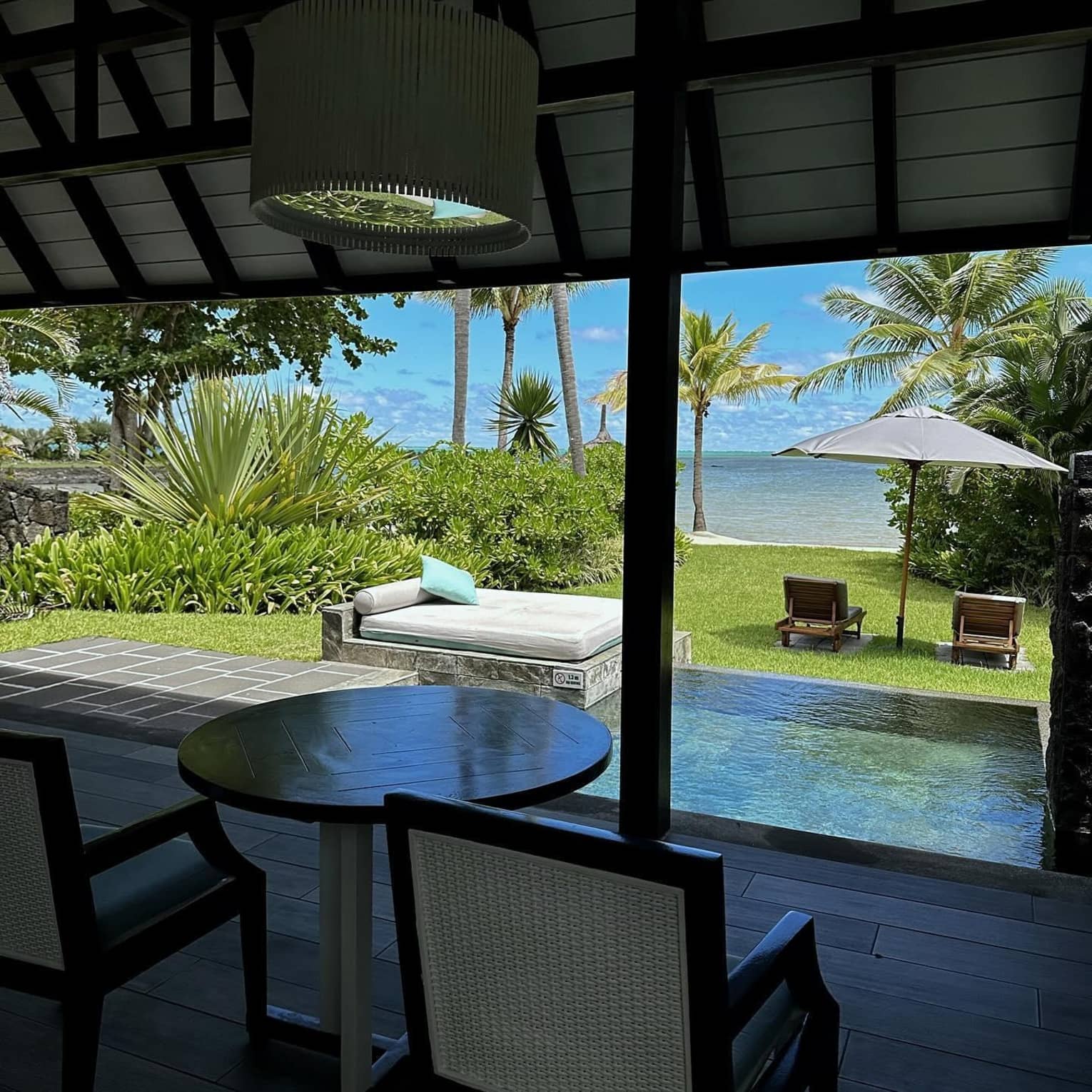 Two outdoor chairs overlooking a private pool, daybed and ocean view