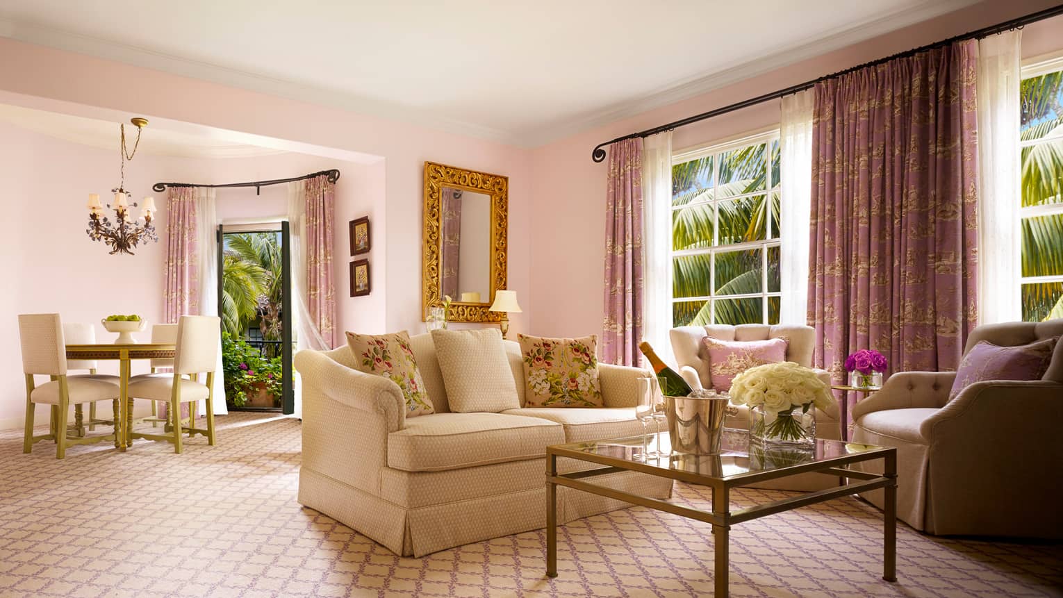 Honeymoon Suite white loveseat, armchairs around glass coffee table, bucket with wine
