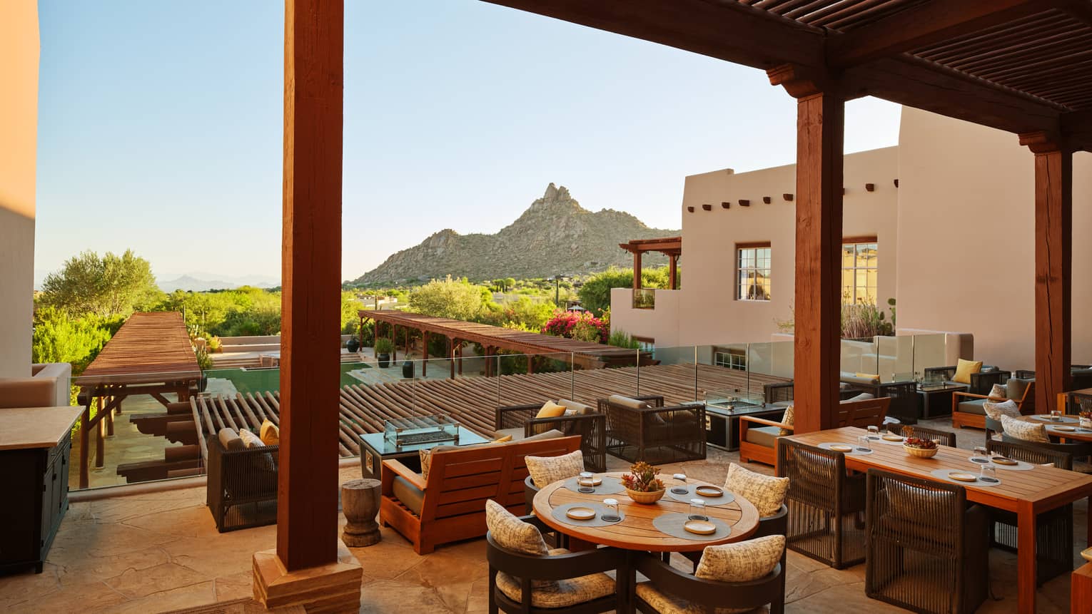 Rooftop dining area with view of the trees and mountains.