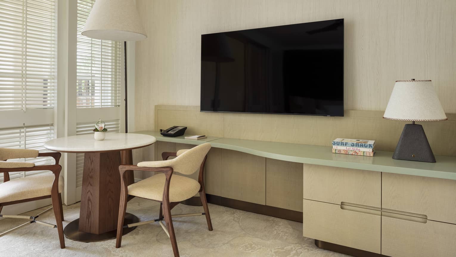 Contemporary resort room featuring a round table with two chairs by a TV