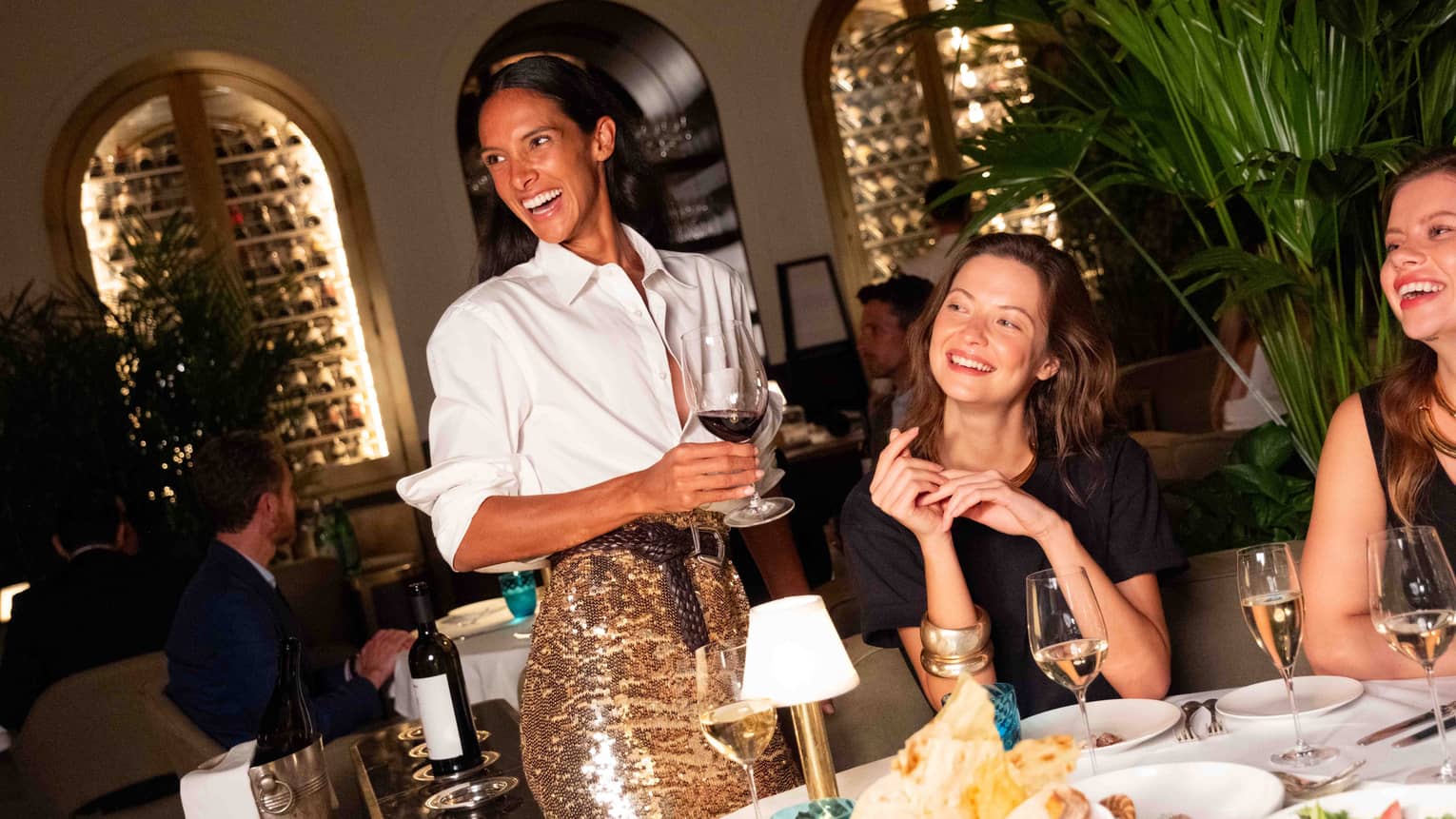 A group of people gathered at a dining table and smiling at one another