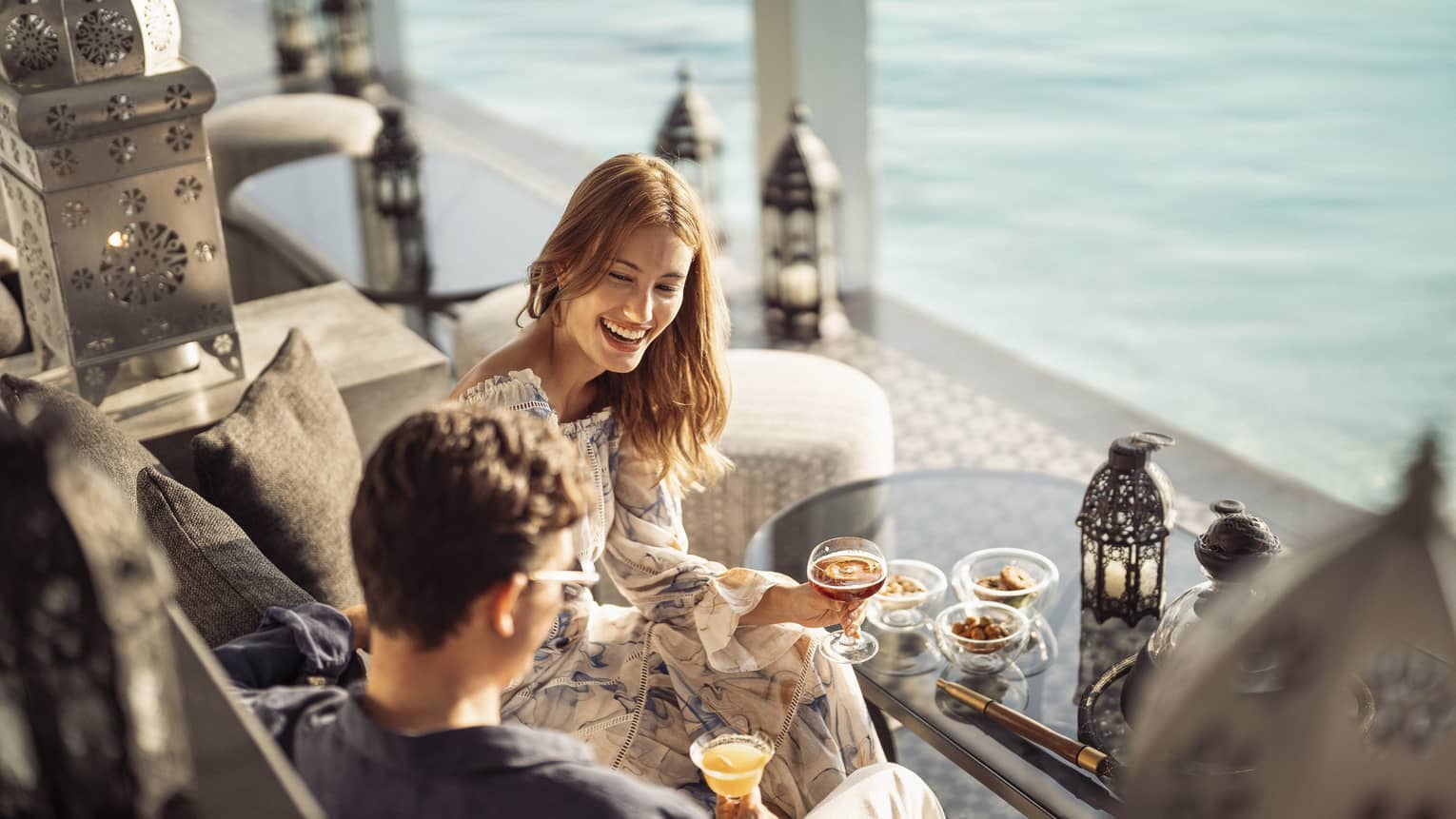 Smiling couple enjoys mezze poolside at Al Barakat