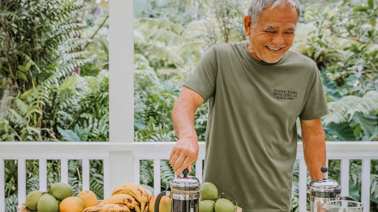 Smiling makes fresh-brewed coffee in a French press on the balcony of a house