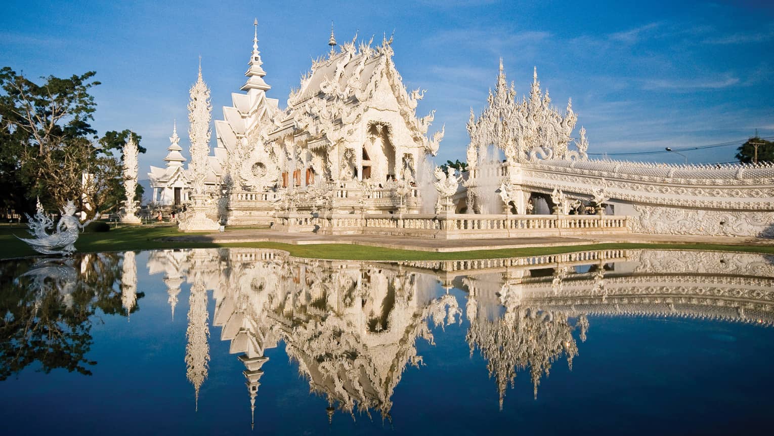 An ornate white castle reflecting in a pond