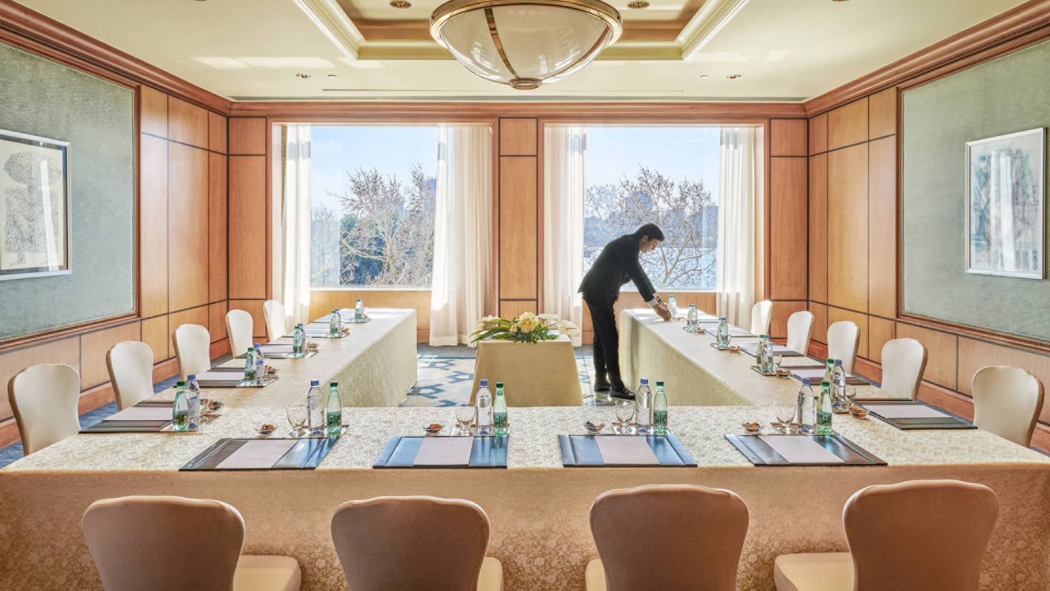 Hotel staff sets modular conference table in sunny Garden City meeting room