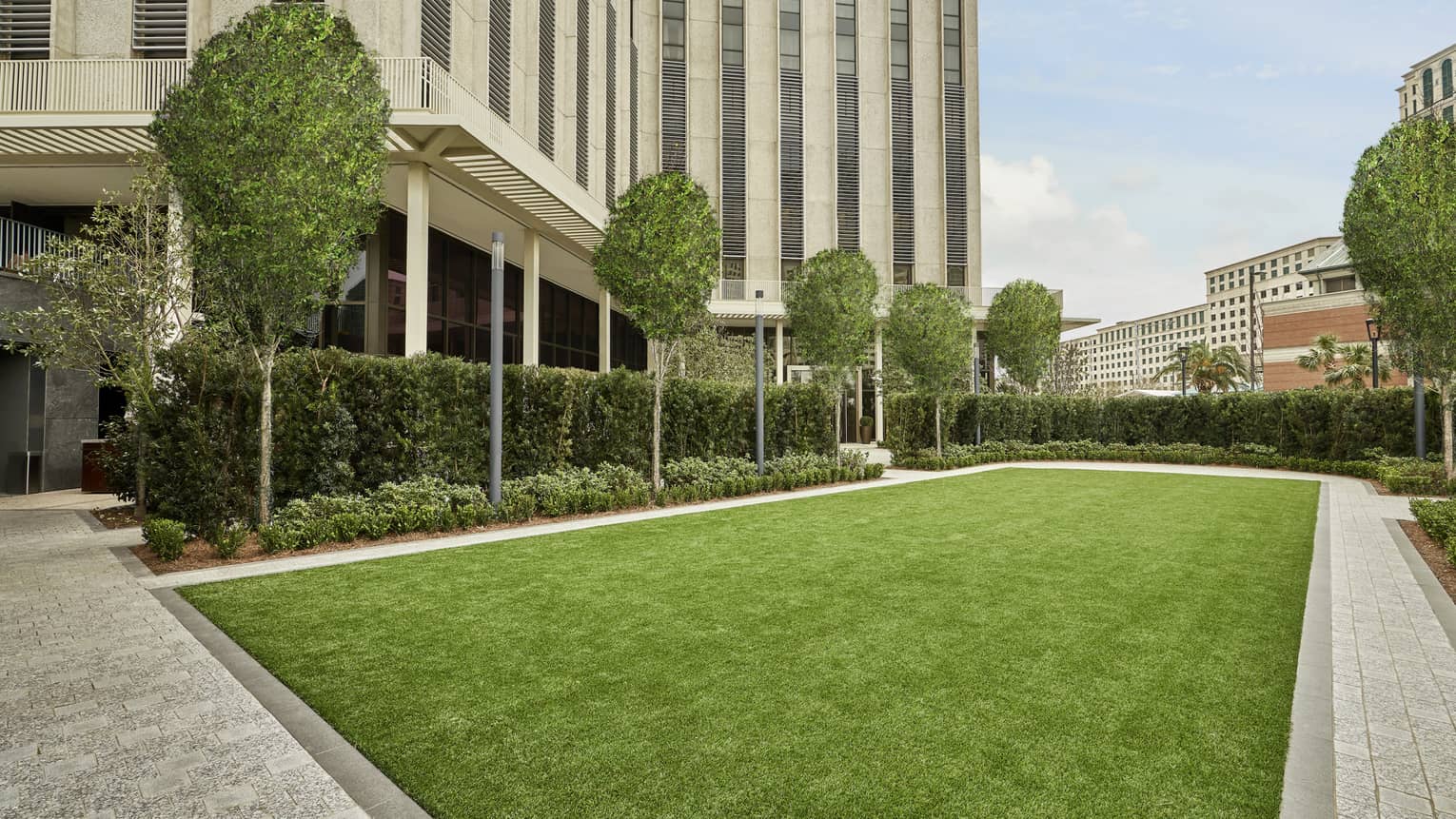 An outdoor area with a lawn of green grass and trees.