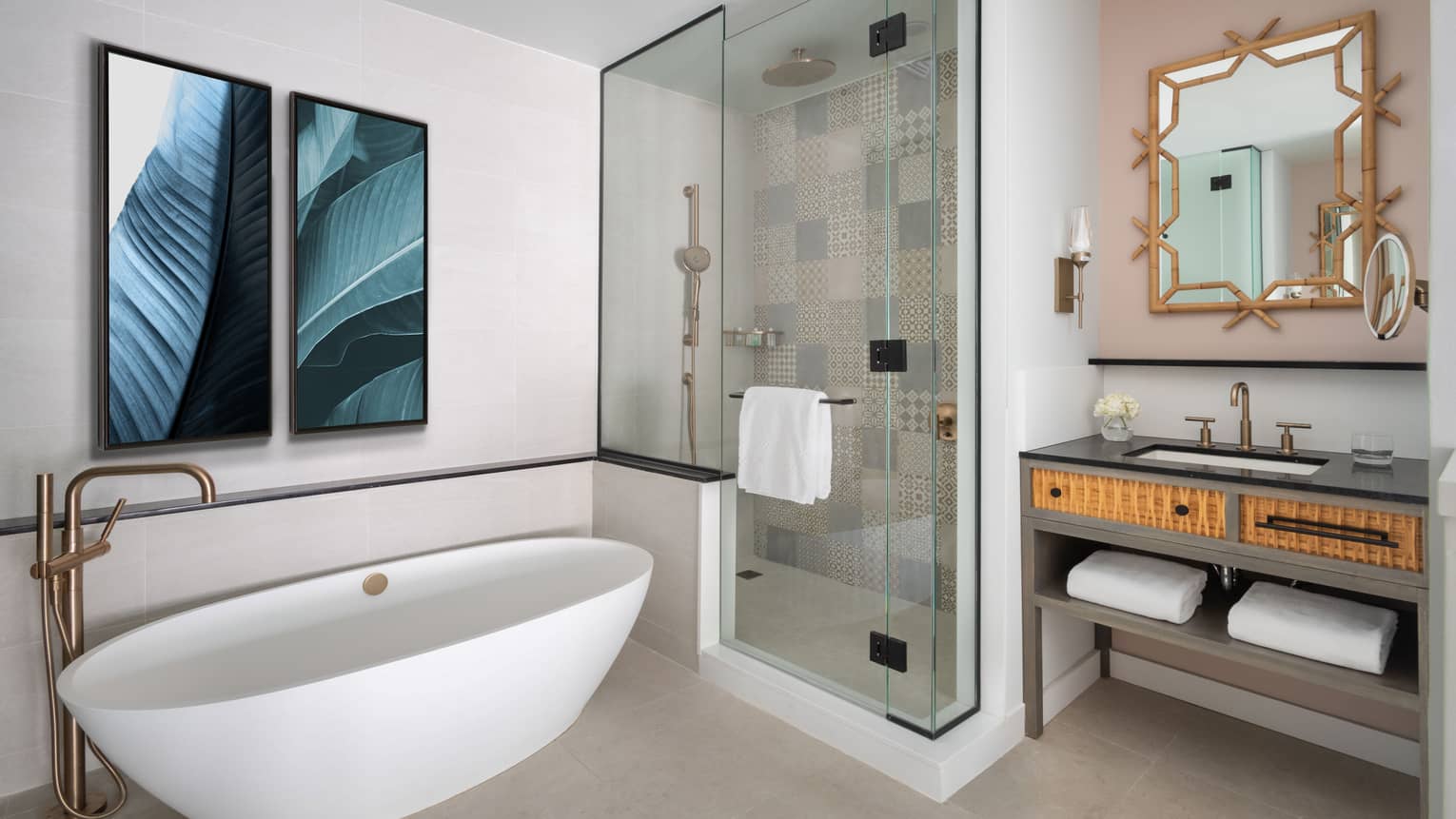 Modern resort bathroom with a freestanding bathtub, glass-enclosed shower and decorative vanity mirror