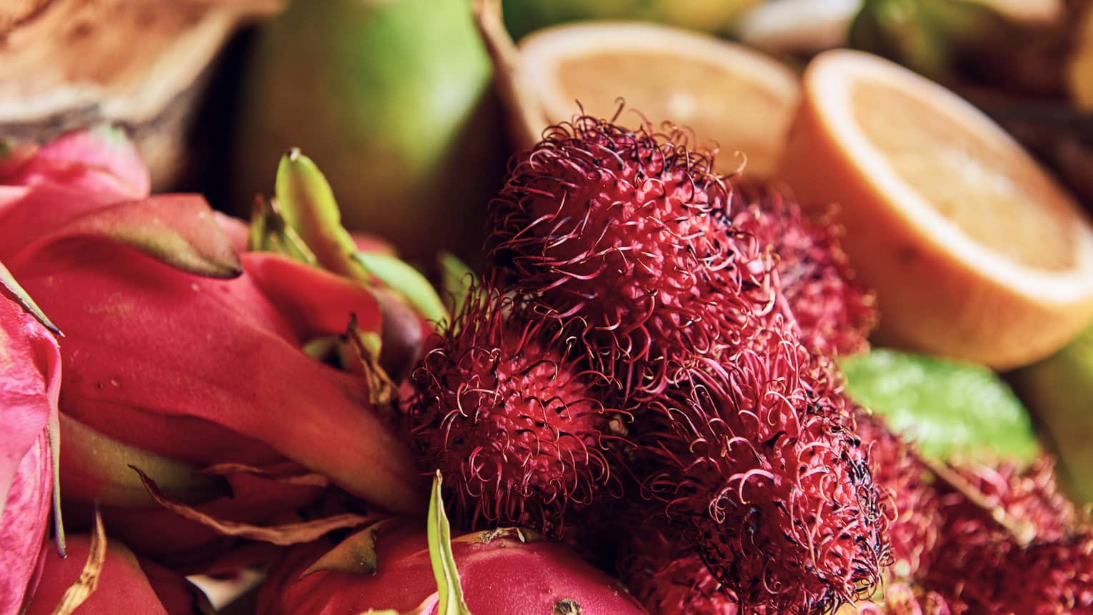 Close-up of tropical lychee fruit, dragonfruit and orange halves