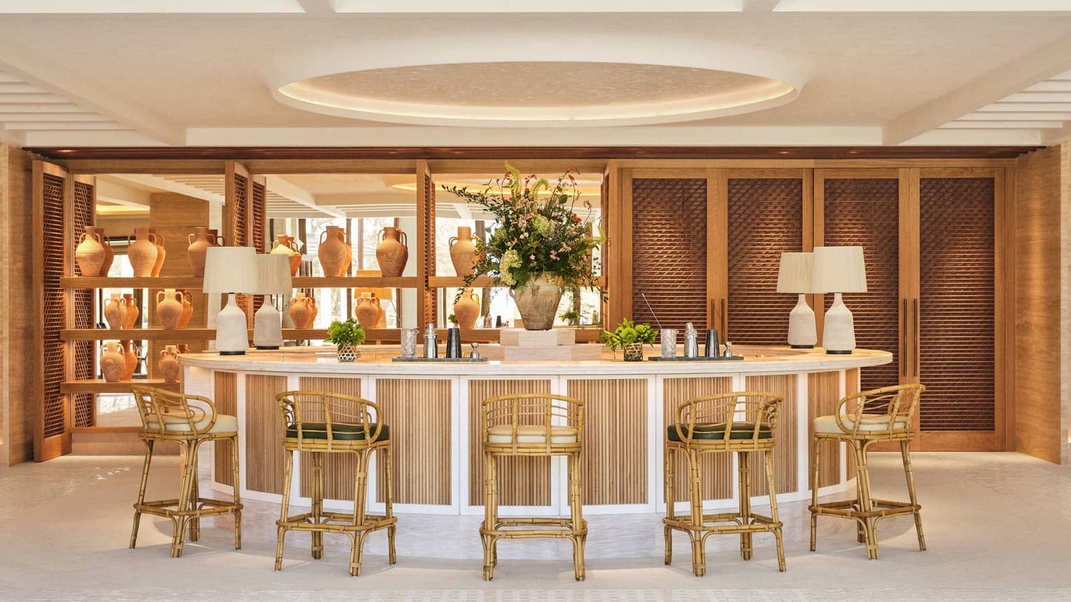 Lobby bar with curved bar counter and rattan bar stools at Four Seasons Resort Mallorca