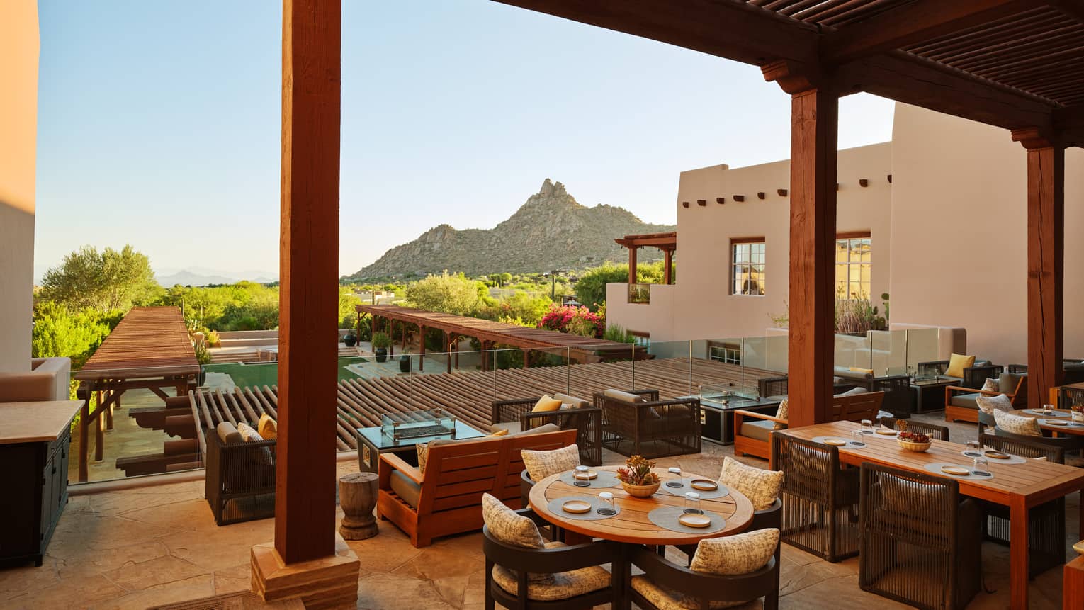 Rooftop dining area with view of the trees and mountains.