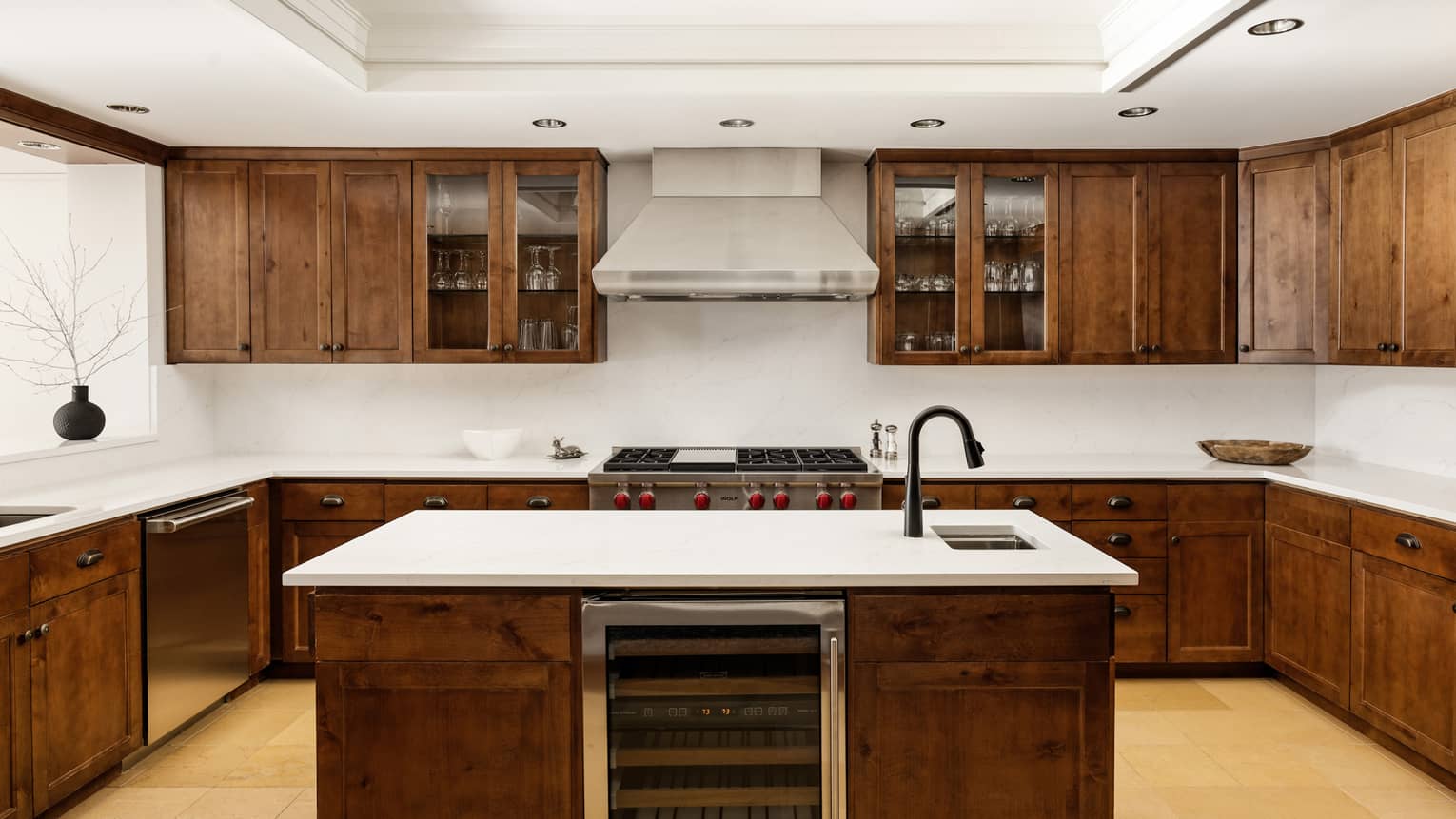 Kitchen with dark wood cupboards, island with built-in wine fridge and sink
